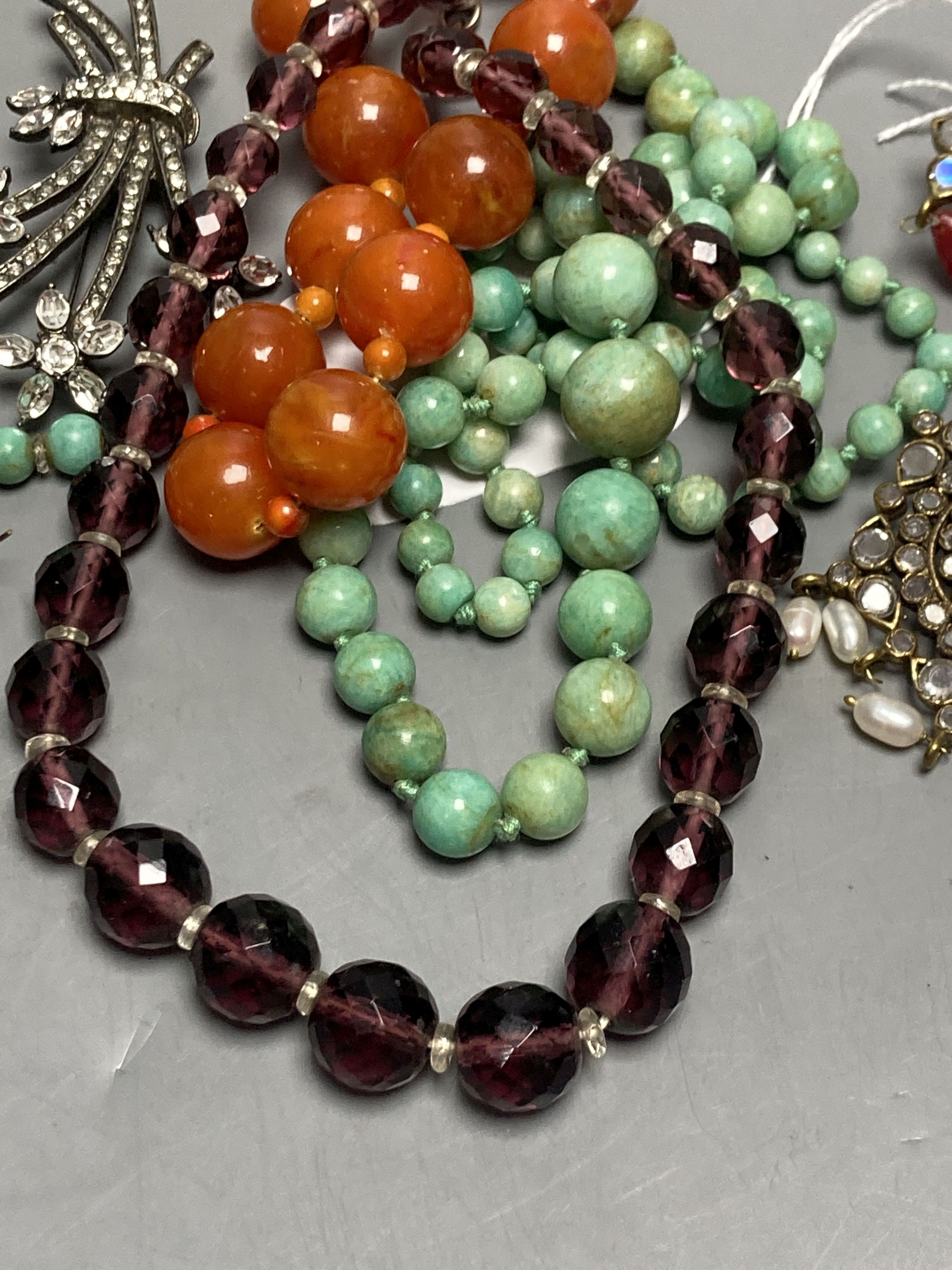 A turquoise bead necklace and pair of earrings, two other necklaces and two brooches including Indian? paste set.